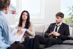 Couple sitting on couch talking with mediator 